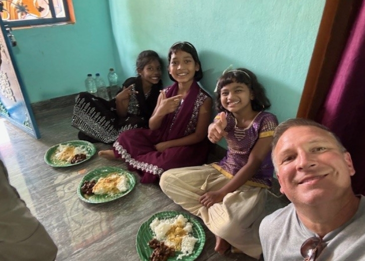 Ryan with orphans eating