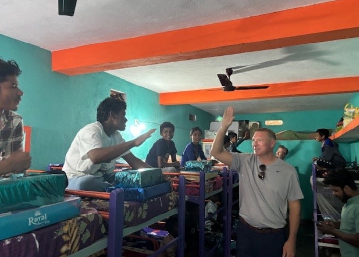 Ryan high-fiving children in bunkroom